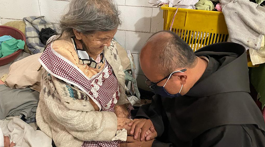 Fr-Joaquin-with-elderly-woman Fr. Joaquin, OFM, praying with an elder in our mission in Guatemala